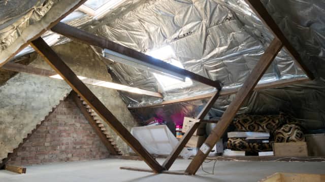 Attic with insulation installed around wood framing